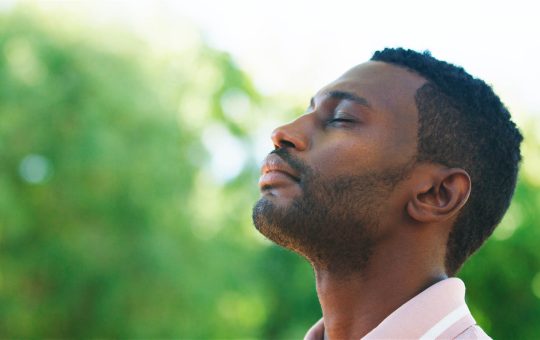 Man Embracing Nature During a Calm Afternoon in a Lush Green Par | Healnex